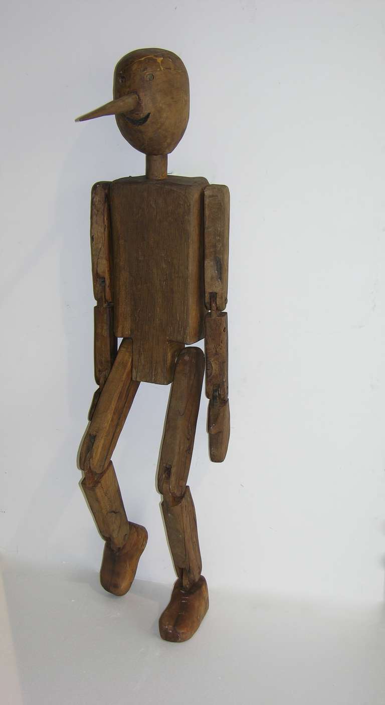 A very rare life-sized Pinocchio sculpture hand carved in Italian walnut, high quality of the execution with articulated arms, hands, legs and feet.