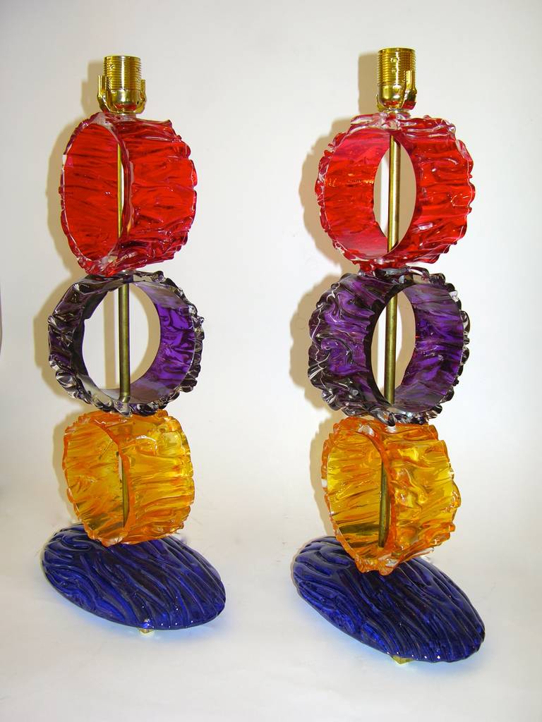 Enticing pair of very colorful Italian table lamps in Murano glass of modern design, the blown hand-crafted glass in the shape of rings has an extraordinary crunched texture, giving an unusual attractive look to these out of the ordinary lamps, on