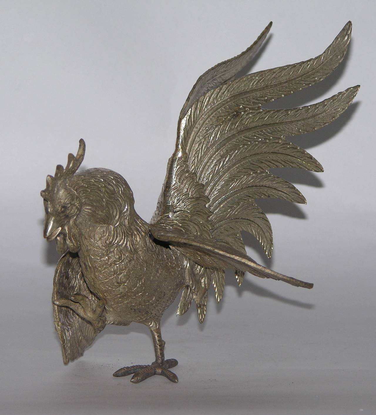 A fun animal sculpture in the shape of a bird: Rooster in walking posture by Gucci, Italy, nicely detailed with chased feathers.