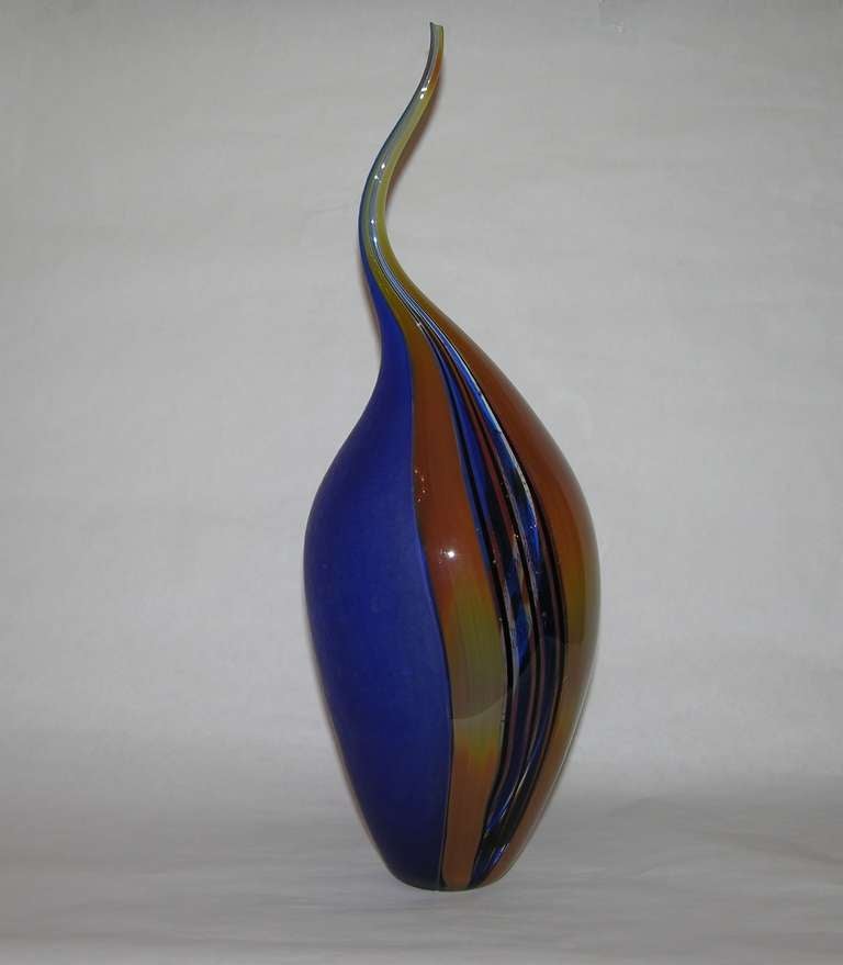 This sophisticated flame shaped design glass vase by Afro Celotto is extraordinarily executed with various techniques, with vertical canes incalmo and reticello, in bright colors of yellow, orange, black and blues . One entire side in blue superbly