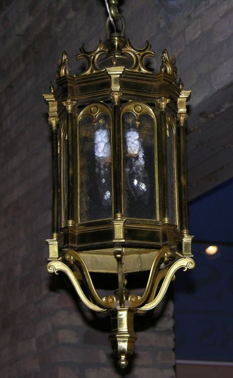 Superbe lanterne française de qualité en bronze coulé lourd, entièrement faite à la main, pièce rare avec de très beaux détails de ciselure et de décoration avec des éléments architecturaux. Huit panneaux arqués en verre texturé sont flanqués de