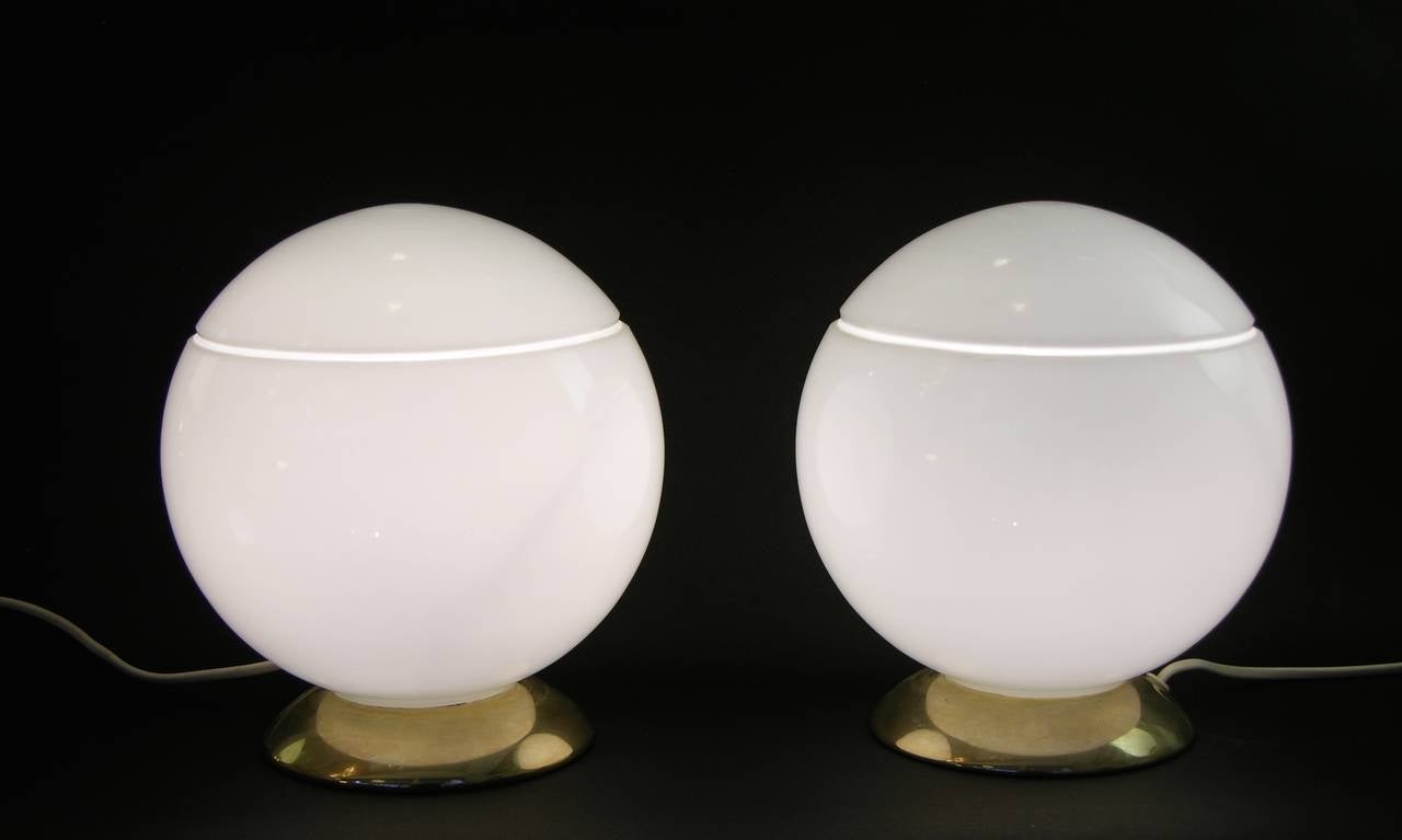 1950s pair of round Italian lamps in high quality silk white Murano glass on a manufactured brass base by the Italian Company Res. These lamps are a gem, with a refined design characterized by an open line running around the top of the globes.
