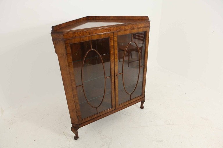Very nice quality mahogany glass fronted corner cabinet with three quarter gallery above two (2) astragal doors enclosing two (2) adjustable shelves, ending on short cabriole feet.  Original key.

Shipping will be $265 by Greyhound.
