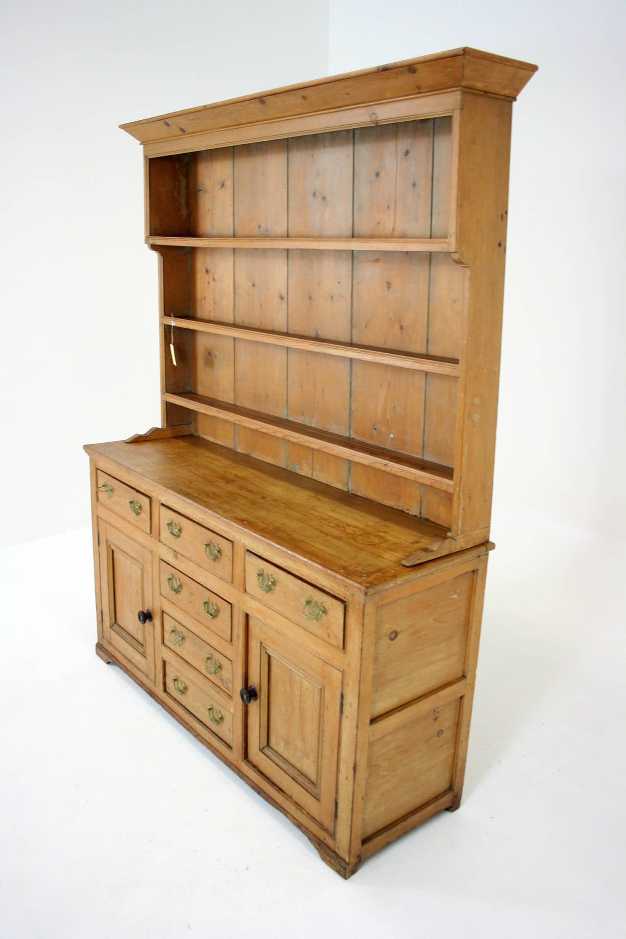 - Wide shaped cornice
 - Top section with panelled back
 - Three open shelves
 - Cupboard base with six dovetailed drawers
 - Two panelled doors with plenty of storage
 - Brass handles, not original
 - Some minor scratches and cracks
 - Top: