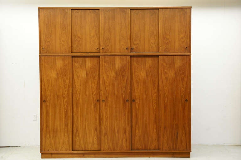 Beautiful five door teak wardrobe, of exceptional quality, dating to the 60′s. Five sliding doors above opens to a single ad shelf inside. Below, five sliding doors open to a hanging rod inside. In the center there are six drawers and four shelves,