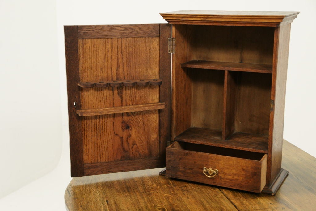 This structurally sound carved oak single door wall cabinet or smokers cabinet has fitted interior to hold pipes and accessories.<br />
<br />
************** Important Customs Information ******************<br />
<br />
Please note, USA buyers