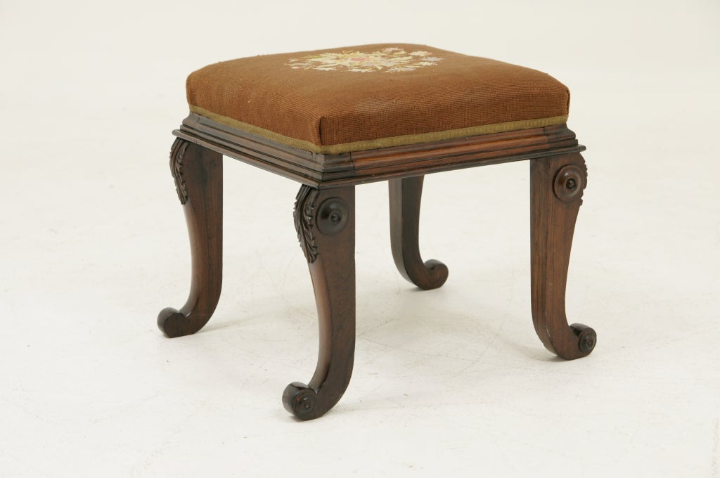 Victorian rosewood foot stool with needlepoint upholstered drop in seat above a plain frieze raised on turned legs.