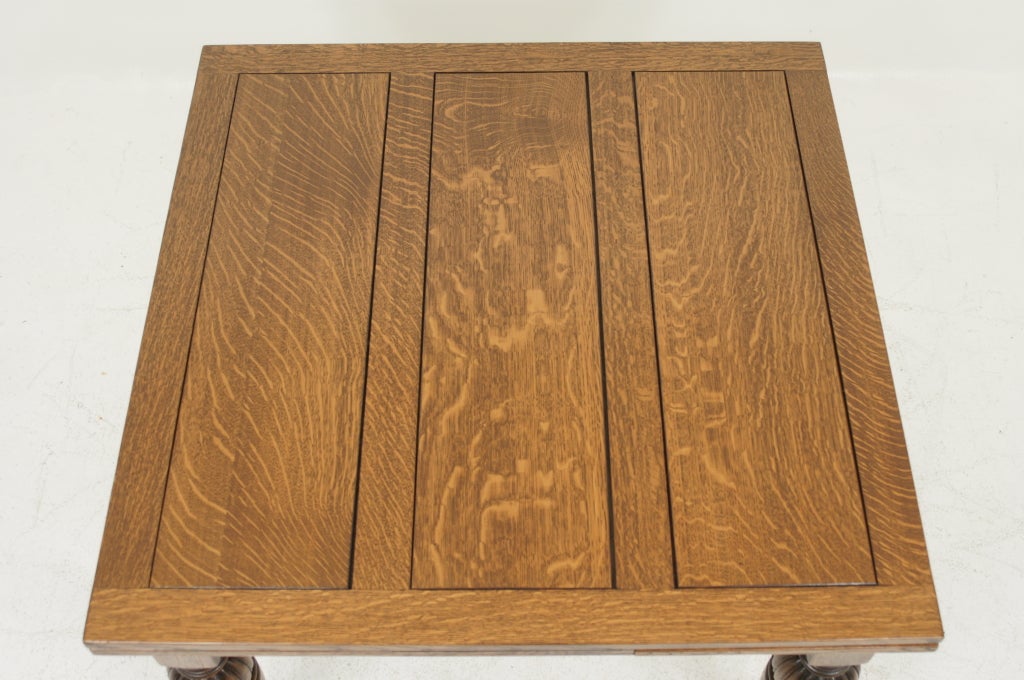Solid, quarter sawn oak extending table with two leaves. Leaves pull out from underneath the enclosed panel top. Raised on baluter legs. Table has recently been refinished. Each leaf measures 15