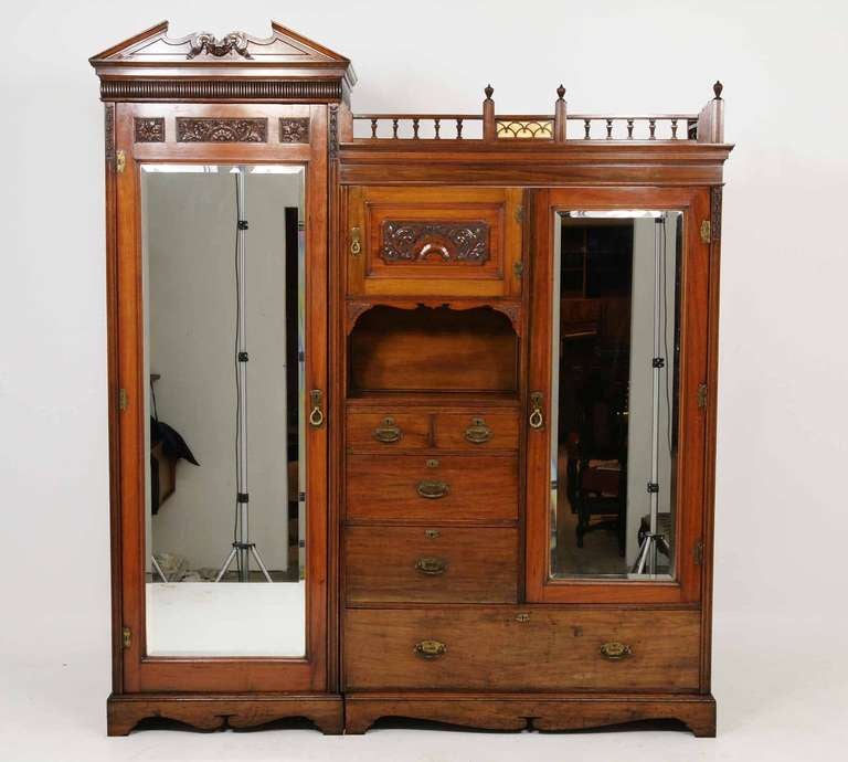 Beautiful Victorian walnut armoire / wardrobe, the projected moulded top with carved shaped pediment, dentil cornice with galleried top, above central cabinet, carved panelled door above shaped open cavity above five (5) drawers, flanked by full