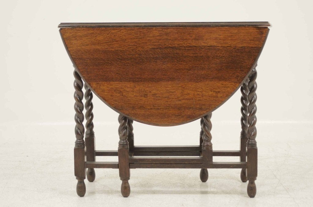 Oak gateleg table, the rounded rectangular top raised on barley twist legs terminating in block and pad feet united by stretchers.