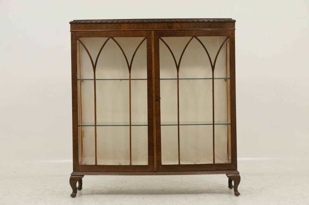 Early 20th century oak bow front china cabinet of rectangular design with two (2) astragal doors enclosing glass shelves on short cabriole legs.  Shipping will be $350 by Plycon.