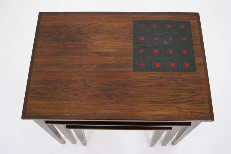 Very nice set of rosewood & tiled nesting tables from Denmark, dating to the 60's. The tiles are in a charcoal, black & red square pattern. These tables would work anywhere and are in good original condition. Shipping will be $120 by
