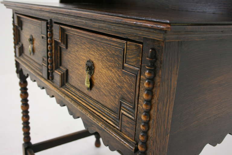 - Scotland, 1910
 - Solid oak construction
 - Separates into top and bottom
 - Original finish, warm patina
 - Panelled drawers w/ brass handles
 - Bobbin legs joined by cross-stretcher
 - Very nice size
 - Bottom: 36”³w x 19”³d x 32”³h