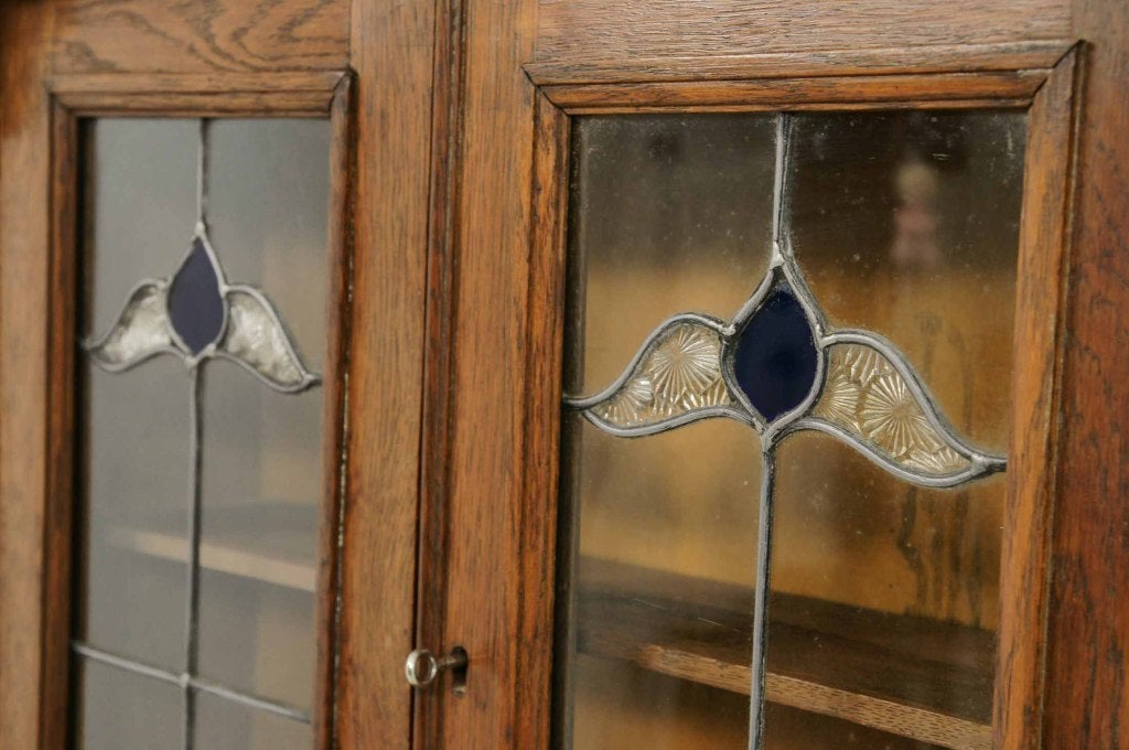 Art Nouveau leaded glass bureau bookcase, with overhang cornice above two (2) stained glass doors, above a fall front with fitted interior and two (2) open shelves below.