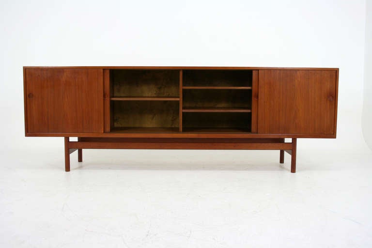 This stunning teak sideboard is simple in it's aesthetic but absolutely perfectly executed in design by Hans Wegner. The construction of the piece is superb. Solid teak legs & inset door handles and excellent joinery and finishing techniques