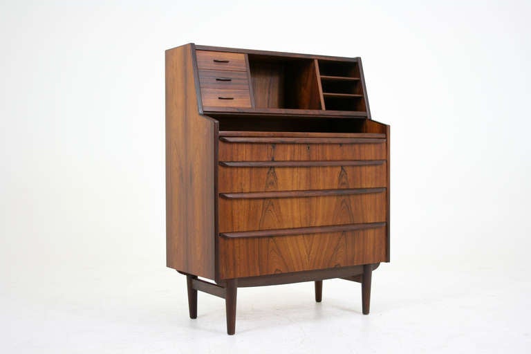 Gorgeous secretary bureau in rosewood with slide out writing table and drawer storage. Three small drawers above and four drawers sit below the writing surface. Lots storage options and great design make this piece stand out. This would compliment