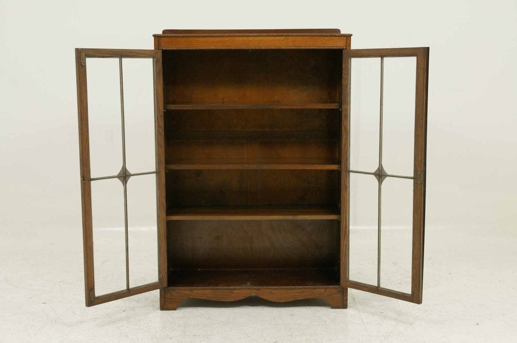 Oak two (2) door bookcase with fretwork glass doors enclosing three (3) adjustable wooden shelves, on bracket feet.

Shipping will be $165.00 by Greyhound.
