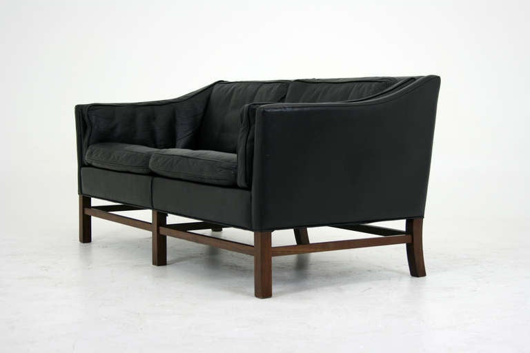 Nice quality Danish two seater sofa in its original black leather. Perfect for condo or apartment living this sofa has a very compact footprint and will add loads of style to your vintage or contemporary living space. Vintage sofa is in good