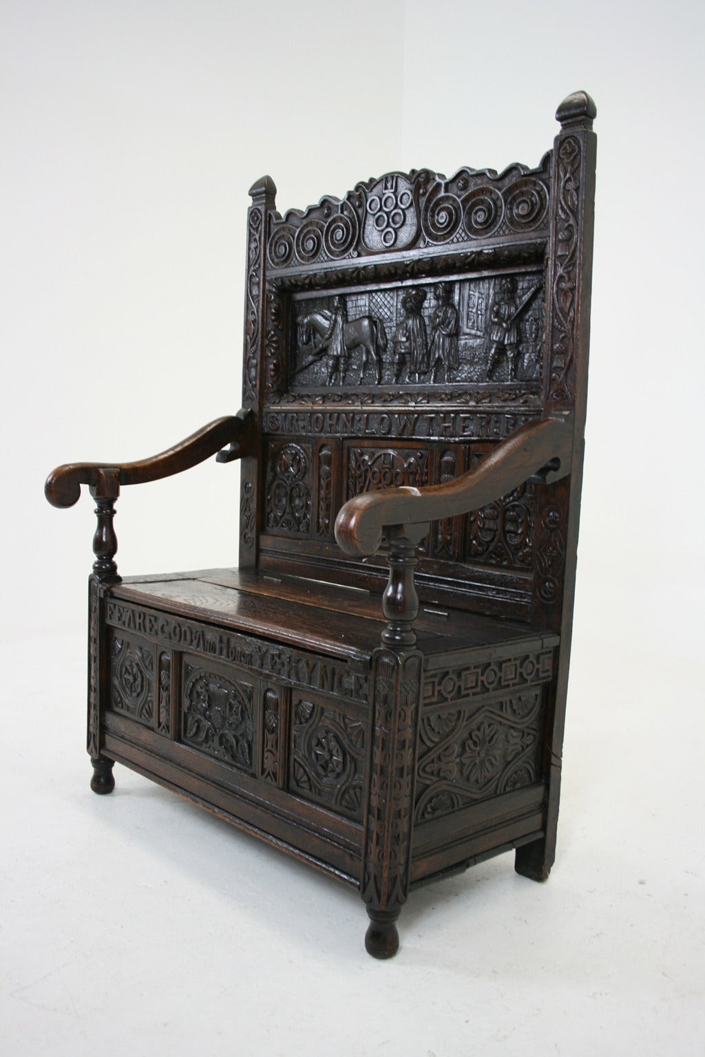 $3950.
England, 1780-1880.
Solid oak construction.
Provenance: Lowther Castle in Penrith, Cumbria.
 Heavily carved back panel.
Jacobean dress coat of arms.
Carving reads: Sir John Lowther Bart. and lower carving reads: Feare God And Honor Ye