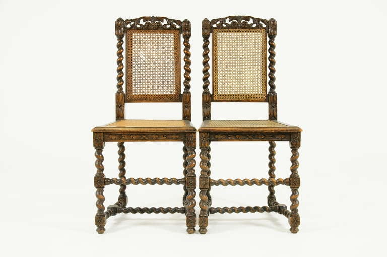 A pair of Walnut Barley Twist Hall Chairs with carved top rail above caned back flanked by barley twist supports.  Caned seat ending on barley twist legs joined by cross-stretchers.