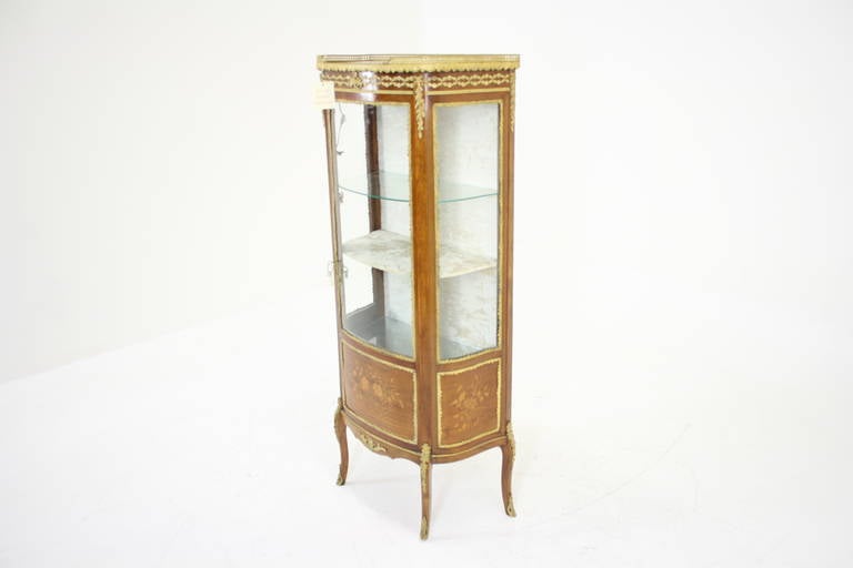 - 2450 $
 - France:: 1920
 - Vitrine en acajou
 - Dessus en marbre avec moulure dorée et galerie
 - Porte vitrée en arc
 - Panneaux incrustés de marqueterie
 - Élevée sur des supports façonnés avec des montures en métal doré
 - 26″w x 14″d x 58.5″h
