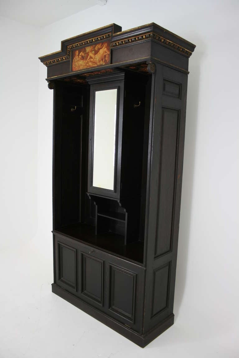 Beautiful dark oak, Victorian entrance piece, hall robe, coat rack with panelled sides, panelled drop-front door revealing a wooden shelf.  Bevelled mirror door opens to two wooden shelves.  Carved cornice above painted scenes, flanked by floral
