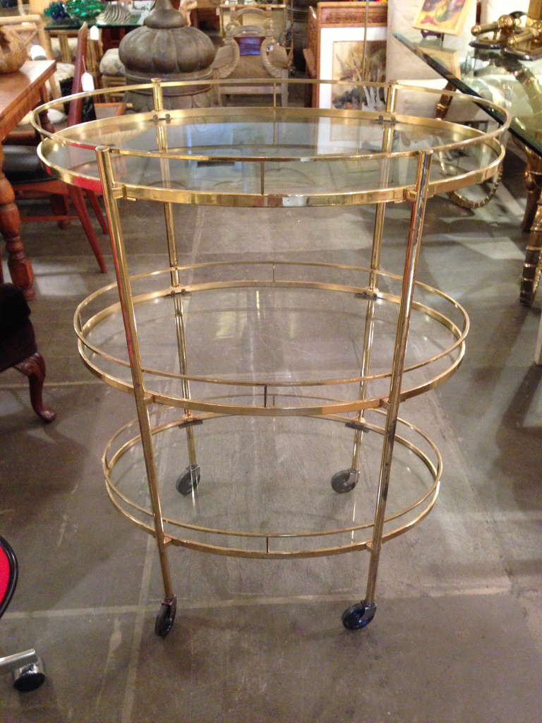 Three tier brass and glass tea/ bar cart. Heavy gage brass and  3 glass inserts. Very elegant lines .Probably French. Rolling casters.
