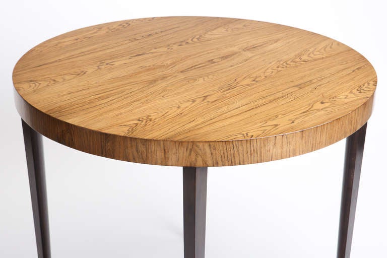 La mesa circular de palisandro blanqueado con patas de madera ebonizada puede utilizarse como mesa de comedor o de juegos. EE.UU., c. 1960.
