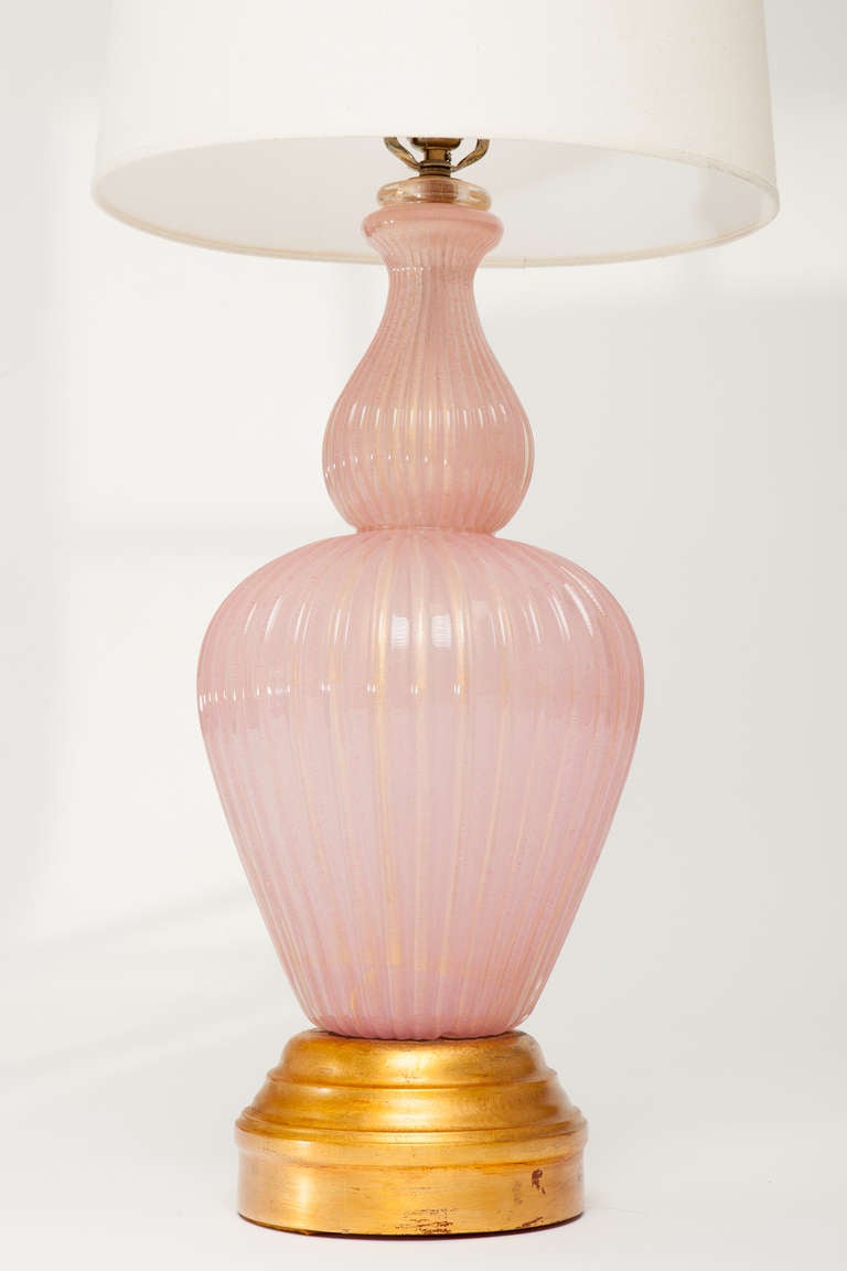 Large handblown pink Murano glass baluster lamp with gold inclusions. Wooden base has gold leaf finish, Italy, 1960s. Glass lamp body measures 24