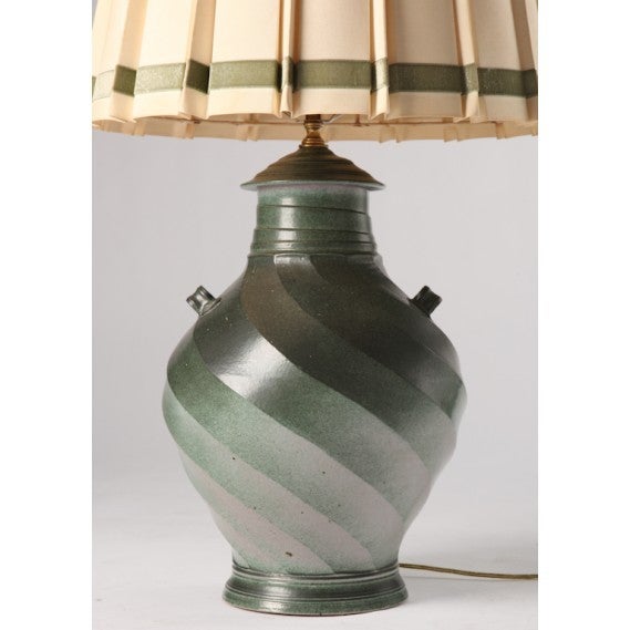 Pair of French glazed ceramic vessel lamps with original pleated lamp shades.