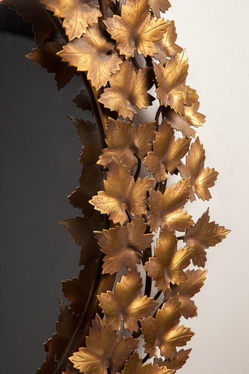 Circular bronze painted metal hand cut  laurel shape mirror with applied leaves and ribbon. Italy,c. 1950's