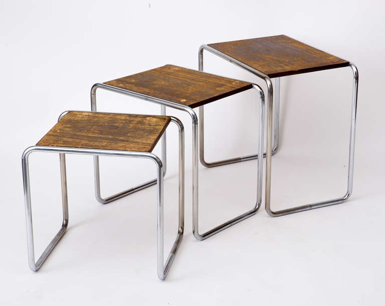 Set of Marcel Breuer B9 nesting tables with chromium plated steel tubular legs and original patinated wood table surfaces, c. 1930. Measurements are as follows:
 Large table 22