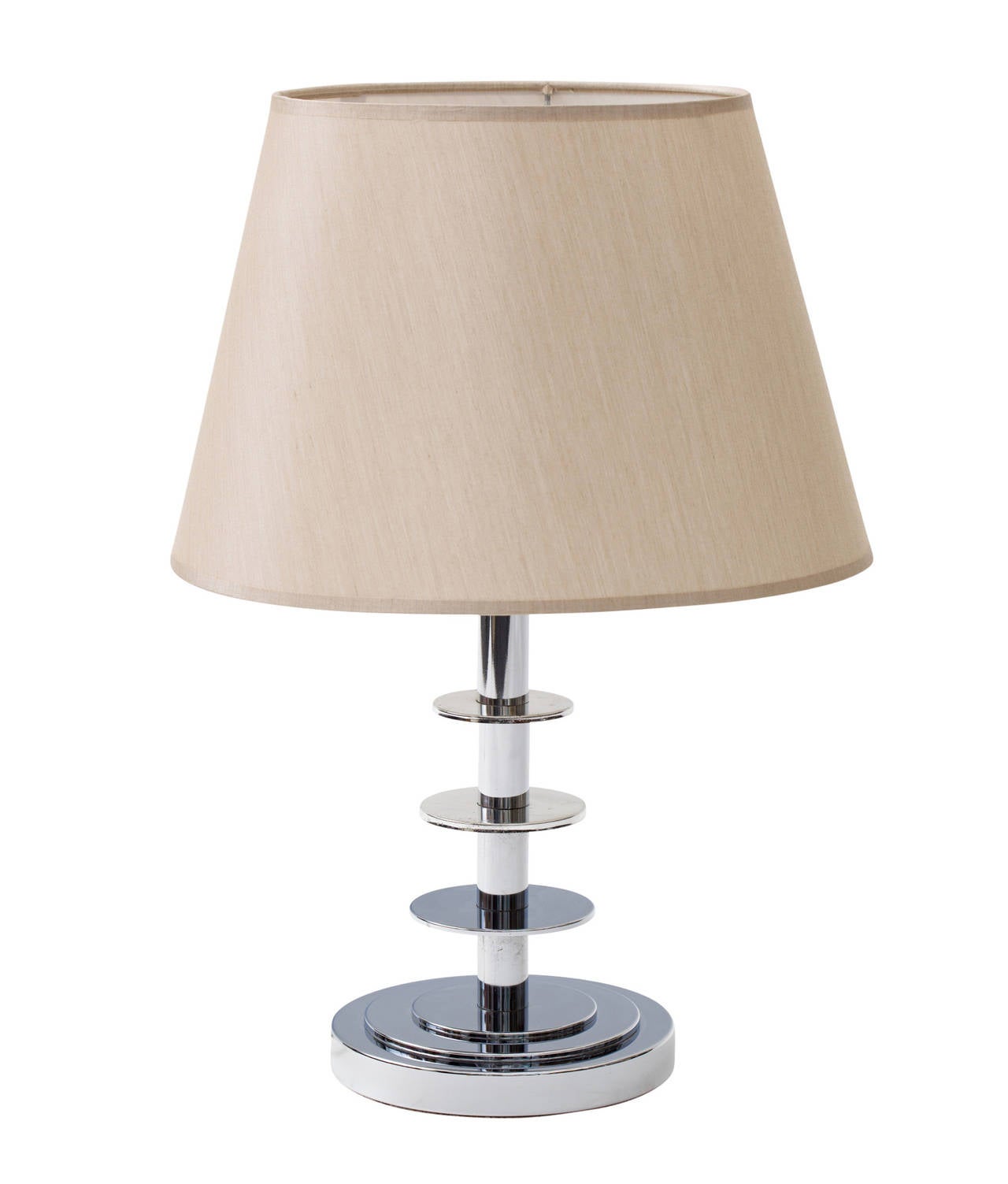 Finely crafted Classic French Art Deco nickeled metal lamp with three circular rings and a round step pedestal base. Double socketed with chandelier bulb sockets.