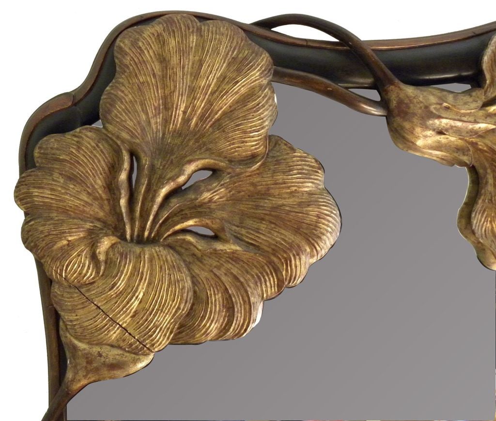 Continental Art Nouveau parcel-gilt mirror, circa 1900. A shaped mirror plate is within a frame carved with large irises and trailing vines.<br />
<br />
An iconic example of the period.