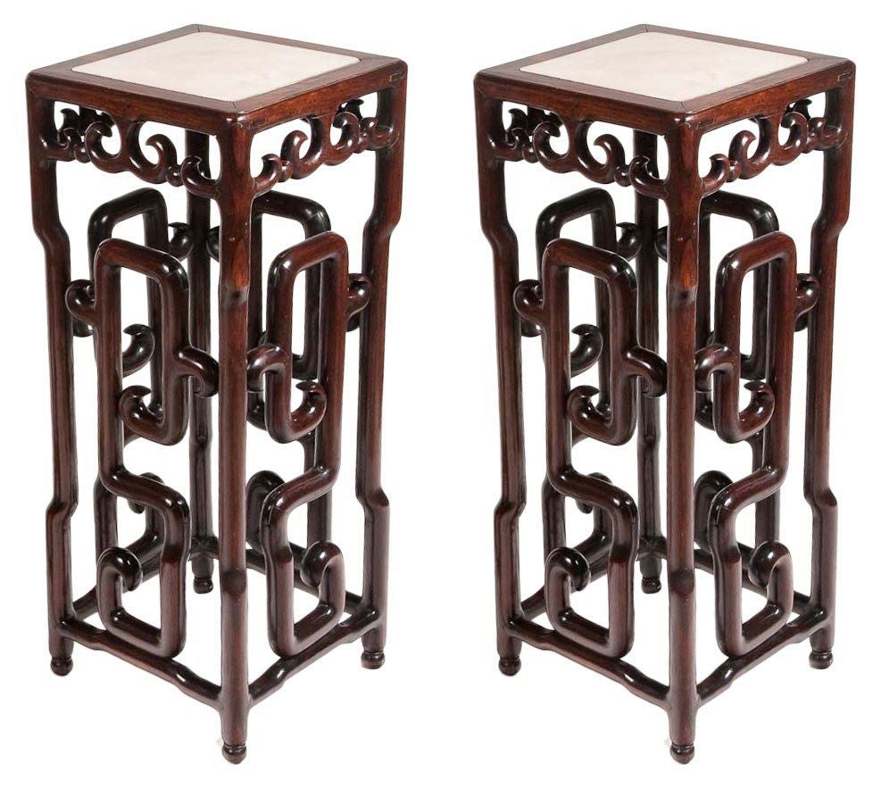 Pair of Chinese hongmu pedestals, circa 1860. Each with a square inset marble top above pierced sides and elaborately shaped turnings, ending in ball feet.