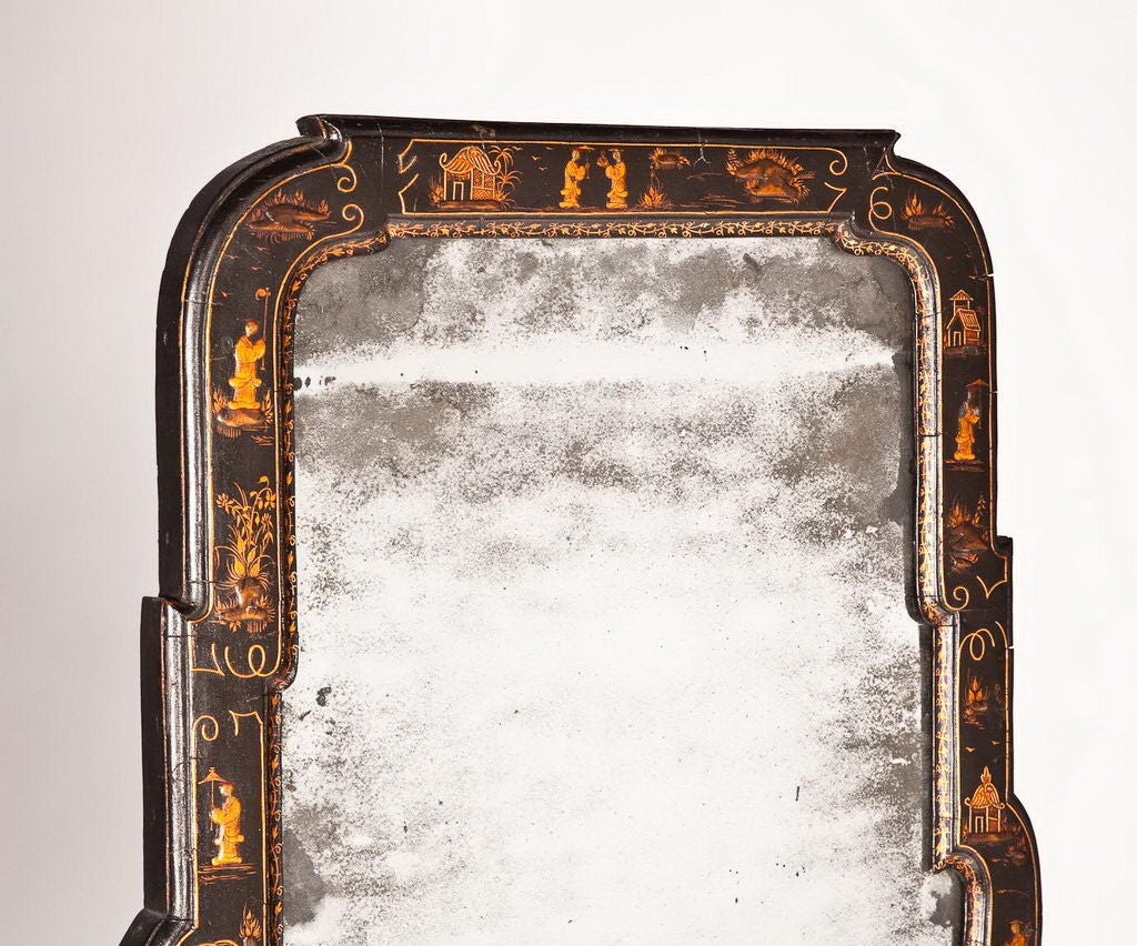 Rare English Queen Anne japanned pier mirror, circa 1710. The two-part beveled mirrored plate is within a chinoiserie-decorated border. Original japanning and top mirror plate; the lower plate an old replacement.