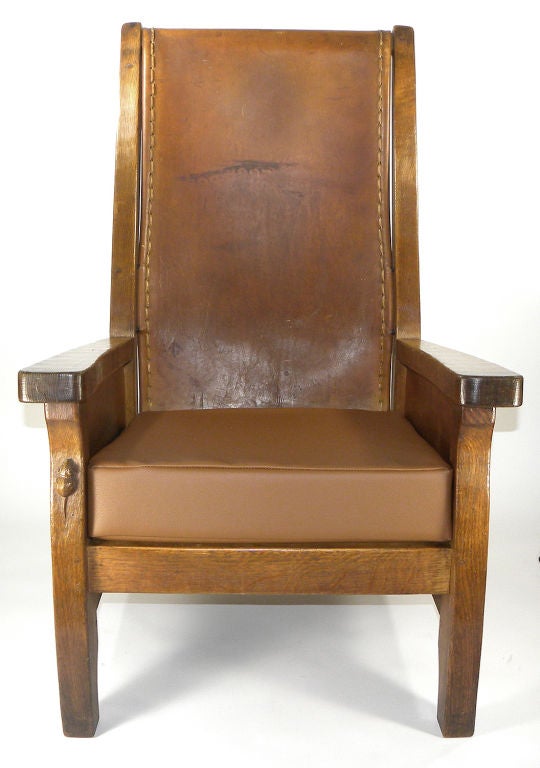 English oak 'Mouseman' armchair, circa 1930's, by Robert 'Mouseman' Thompson (1876-1955), Kilburn, North Yorkshire. The original leather back with straight top rail and square tapering uprights, tapering arms on paneled sides with shaped supports