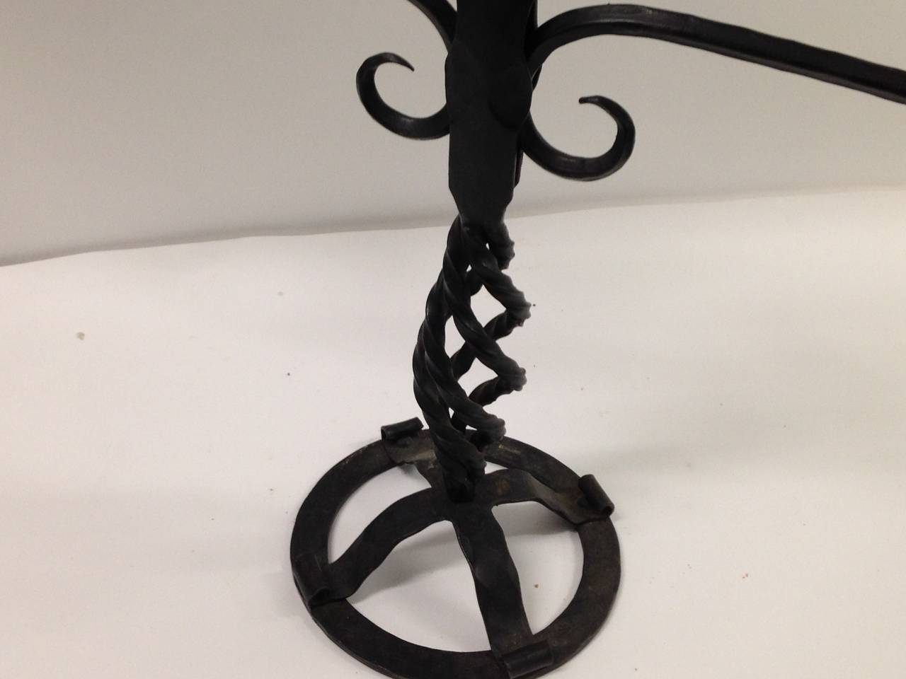 Hand-forged iron with open strap work base, twisted shaft rising to a Silhouette
of seven arms. Each square bobeche is ornamented with a pair leaves. Stamped on base 