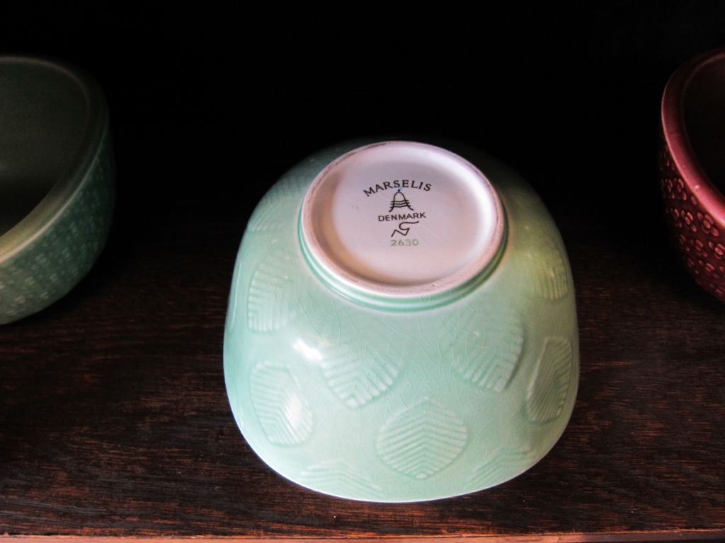 Essence of 1950s two bowls with stylized flower motif (chocolate/seafoam) one slightly larger with leaf pattern covered in seafoam matte glaze. Marked 