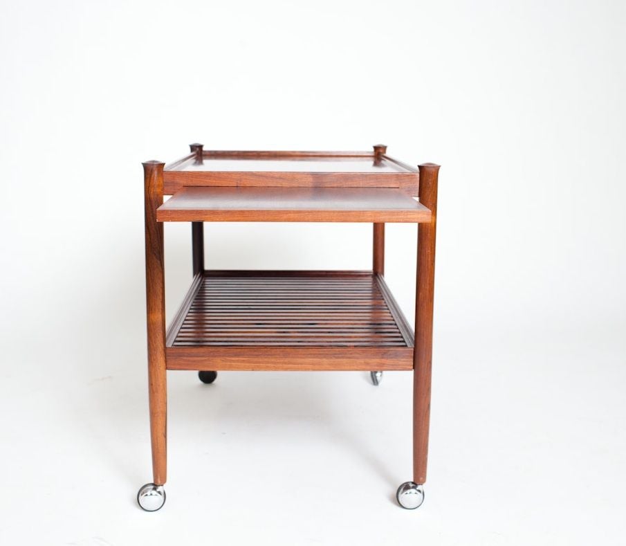 Poul Hundevad designed Rolling Table-Side Cart, circa 1960. Cocktails anyone? This vintage rosewood rolling cart is outfitted with everything you would need for serving in style. From the pull- out tray to the swivel chrome casters this piece brings