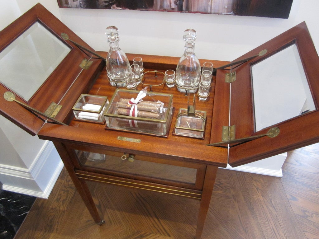 Exquisite piece of furniture.Crystal bottles, crystal shot glasses, crystal cigars holder, cigarettes holder and matchbox holder/ashtray are positioned in brass holders. Lake a magic by closing the top, everything is brought down like an elevator.