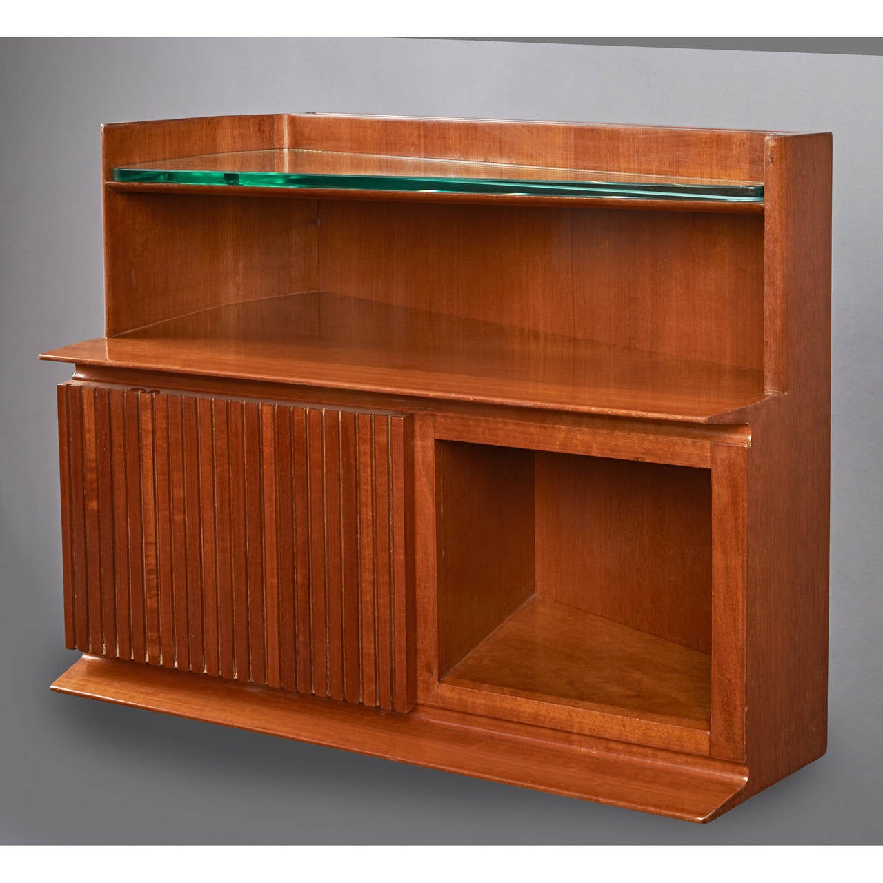 Italy, 1950s.
Pair of angular mahogany wall-mounted trapezoidal bedside tables with open niche and enclosed storage with hinged door. Glass lined shelf above.
The cabinet tapers in towards the bed for ease of access.
Measures: 23.5 W x 14 D x 18