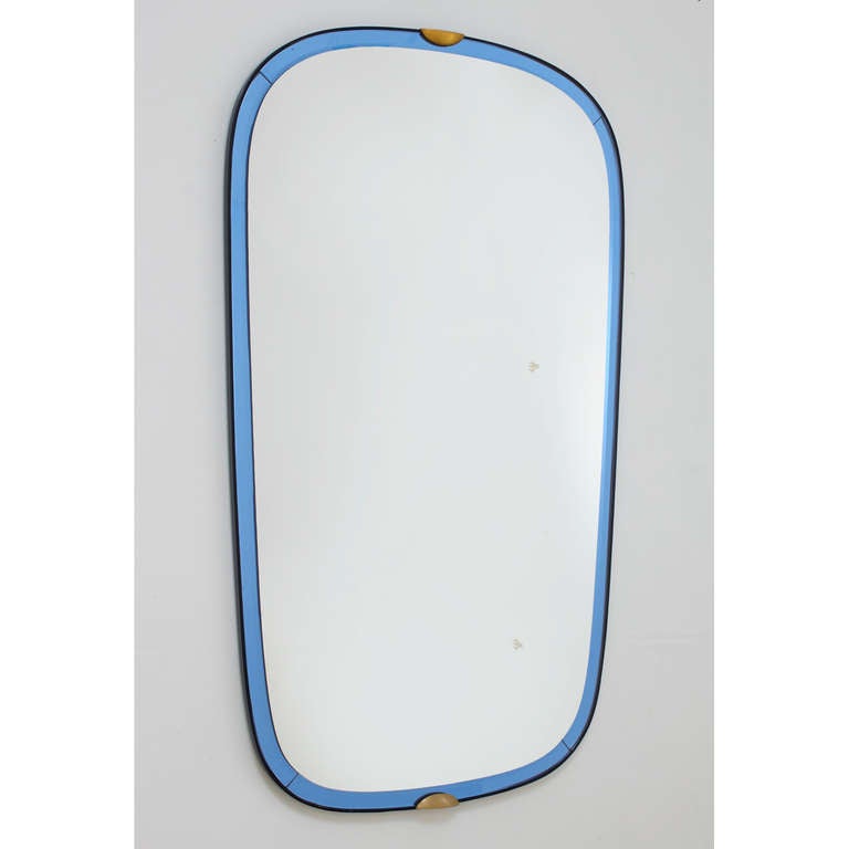 Fontana Arte.
 
An important elongated beveled mirror, bordered with blue mirrored glass; 
black ebonized wood frame; bronze mounts.
Bears the maker's label on back
 
Italy, 1950s.
 
Measures: 43.5 H x 25.5 W.