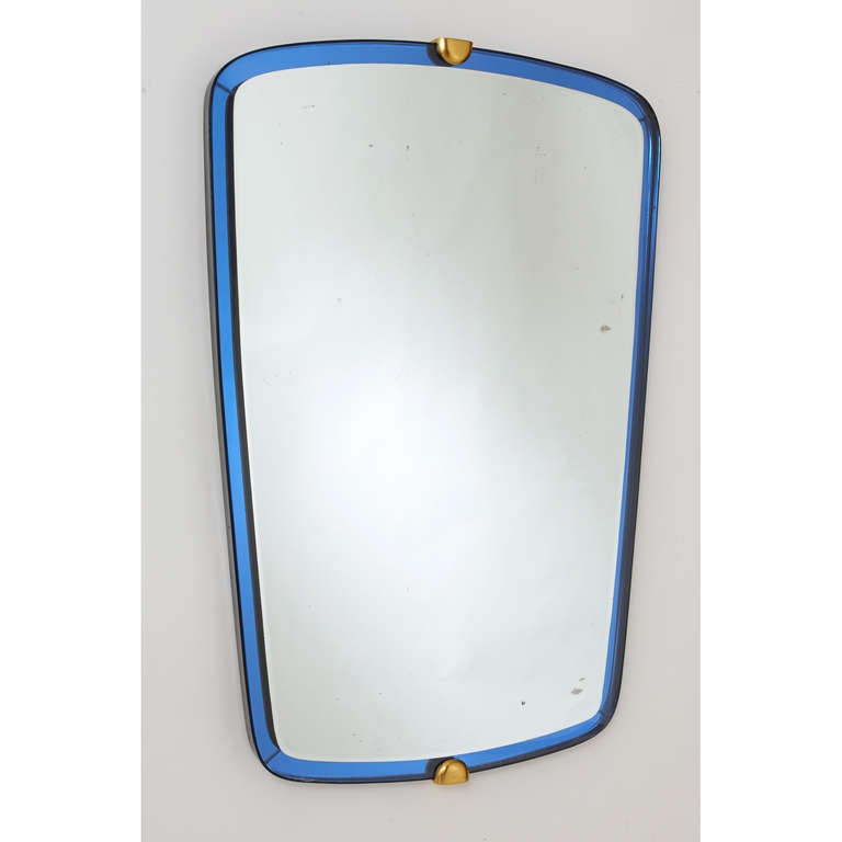 Fontana Arte.

A striking beveled mirror by Fontana Arte,
bordered with dark blue mirrored glass; black ebonized wood frame;
bronze mounts.
Italy 1950s.
 
Measures: 24 W x 36 H.