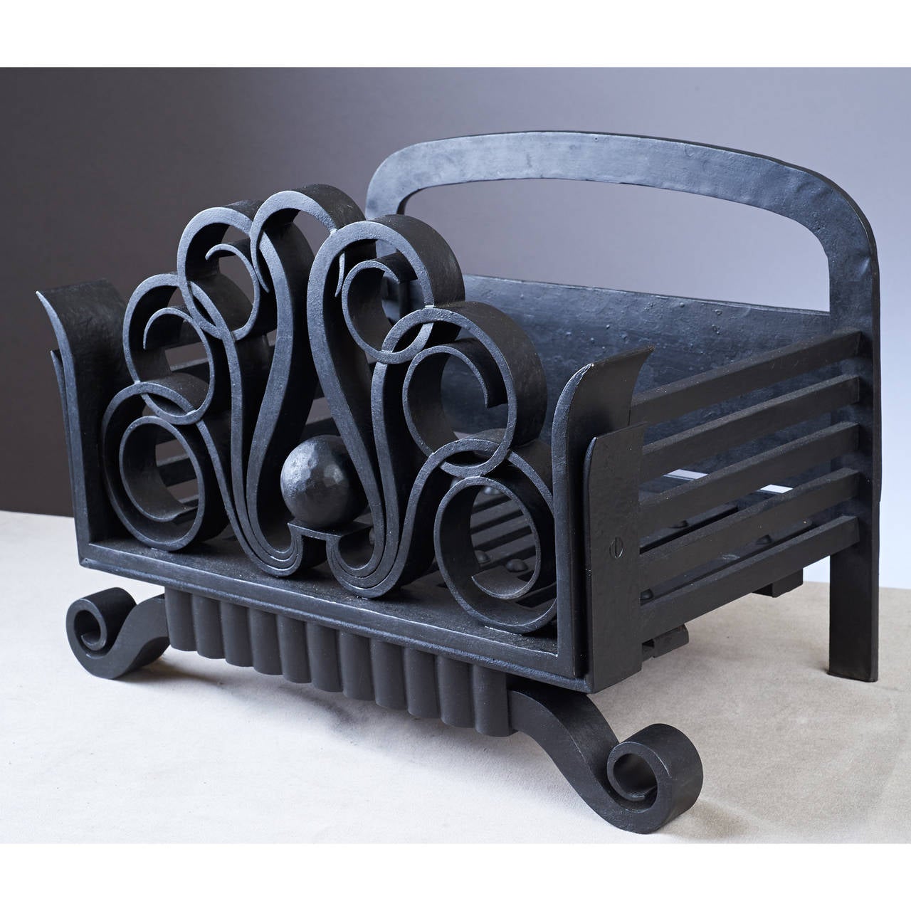 Raymond Subes (1893-1970) in the manner of.

Wrought iron log carrier with scroll motifs,
France, 1930s.
Measures: 18 W x 11 D x 12 H.
