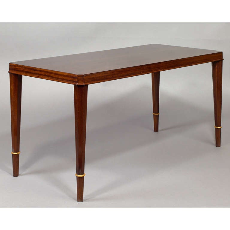 Dominique.

André Domin (1883-1962) and Marcel Genevriere (1885-1967).

An elegant mahogany table raised on sculpted tapered octagonal legs with bronze decor,
France, 1950s.
 
Dimensions: 40 x 18 x 20 H.