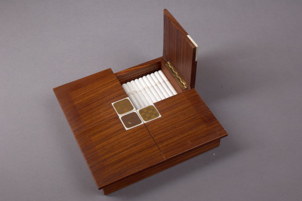 Rosenthal, Studio Line
Wood cigarette box with four decorative porcelain tiles with gold glaze by Bjorn Wiinblad
with round label Rosenthal Germany at bottom.

 