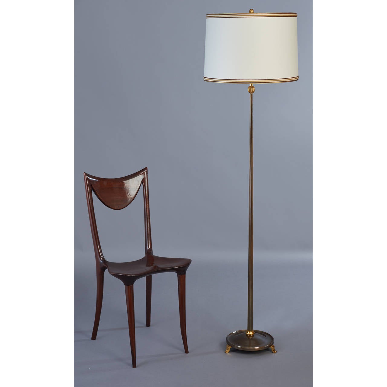 Delisle.

Elegant floor lamp in gilt and oxidized bronze with fluted tapered shaft and
chiseled bronze mounts,
France, 1950s.

Rewired for use in the USA with two standard base bulbs

Measures: 65 H x 17 diam.