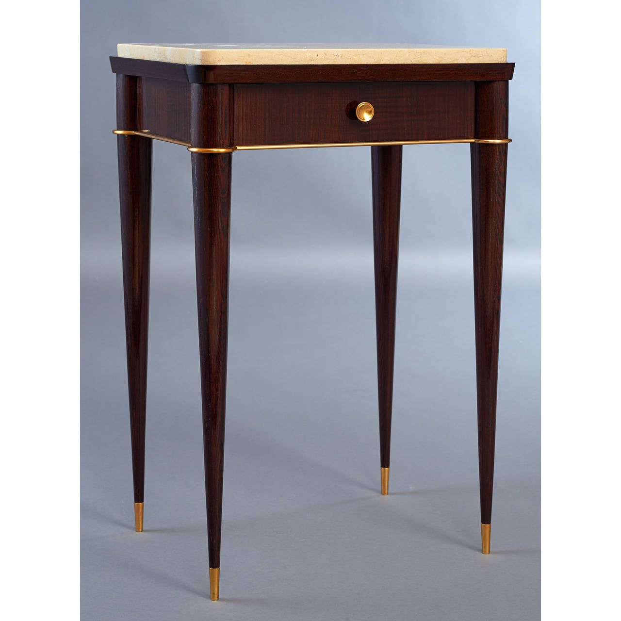 Batistin Spade (1891-1969).
An exquisite pair of side tables with drawer, in mahogany stained oak with polished marble tops and bronze mounts, the stiletto tapered legs terminating in bronze sabots.
Finished on all sides, may be used