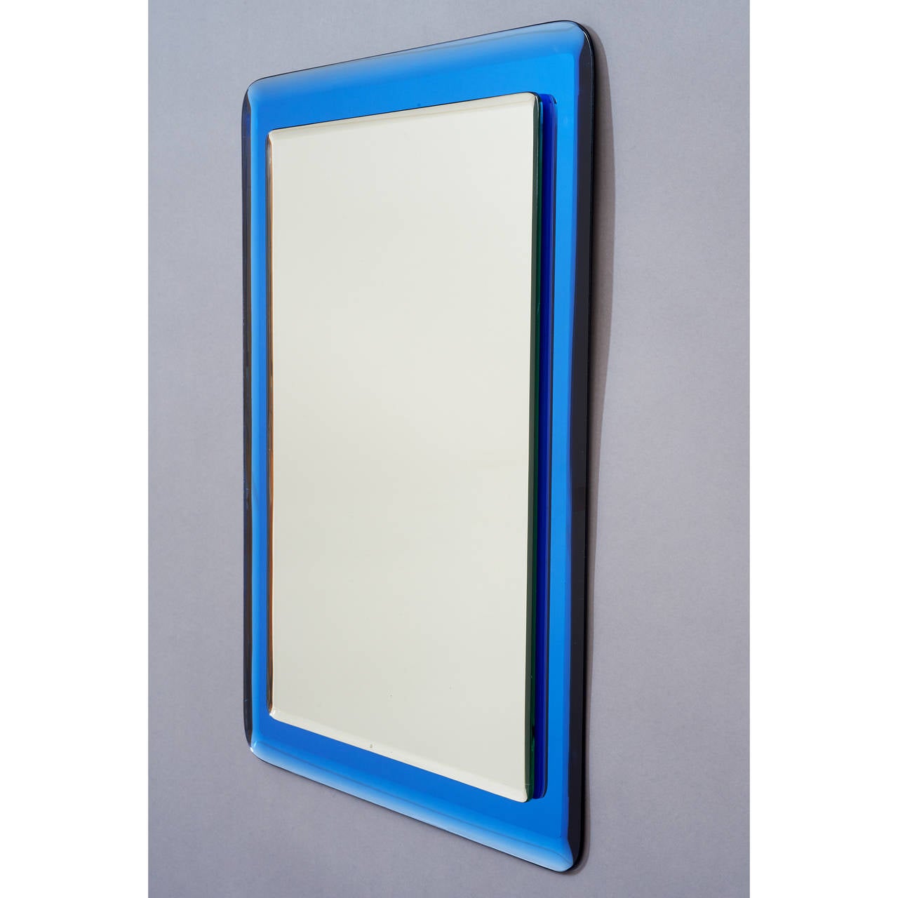Italy, 1970s.
Elegant reverse beveled mirror mounted on reverse beveled blue mirrored glass, with rounded corners.
20 W x 28 H 


